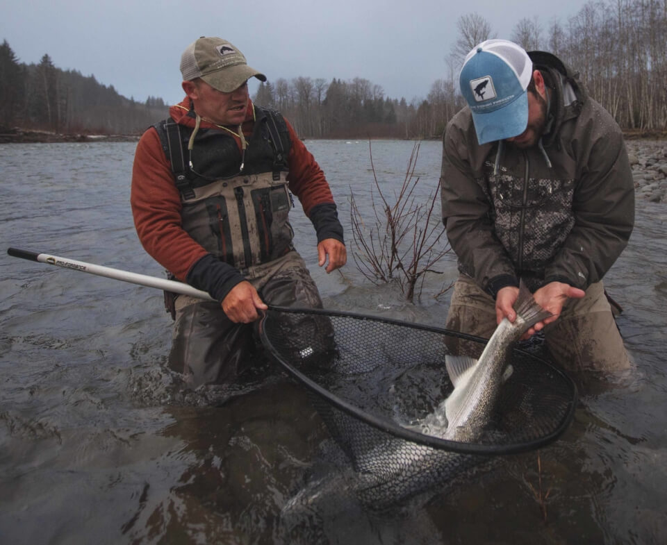 Two people fishing in river.