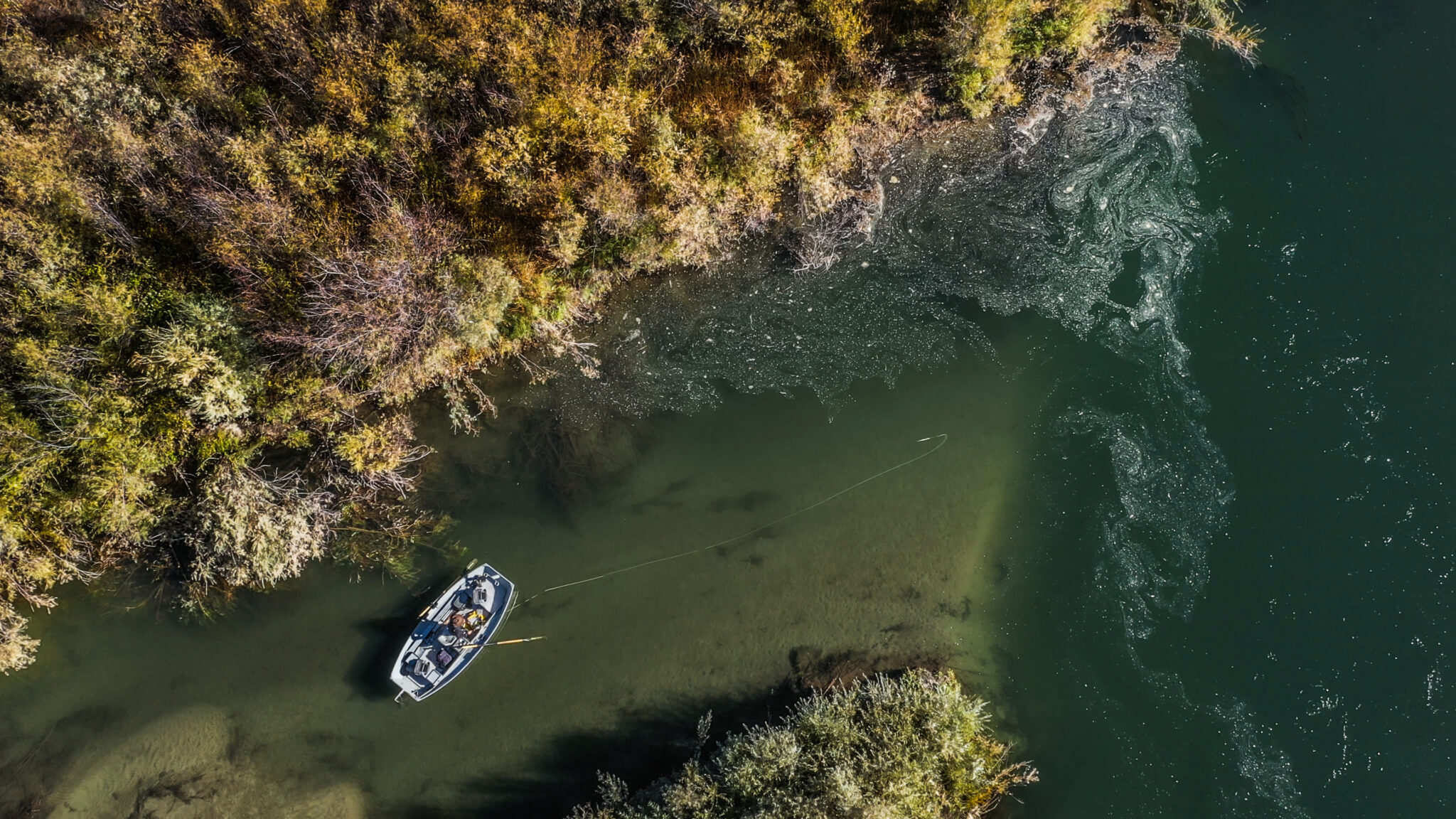 Top down view of fisherman in boat casting.