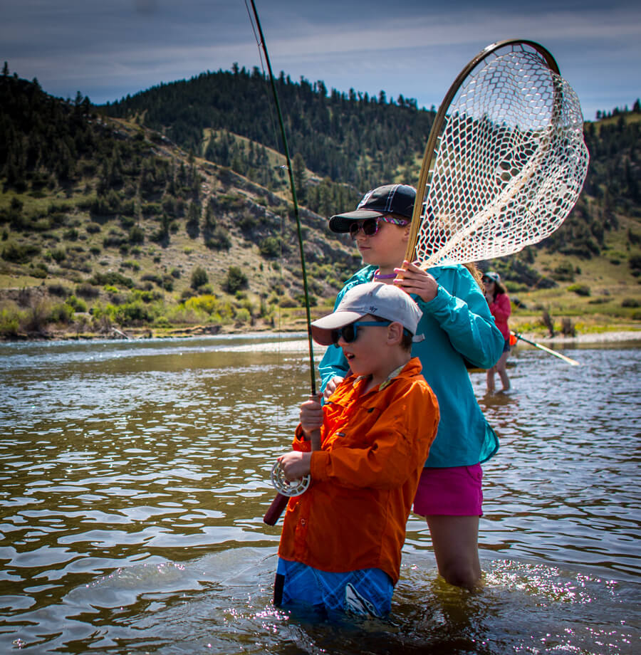 kirkmissouri Kids fly fishing in river.